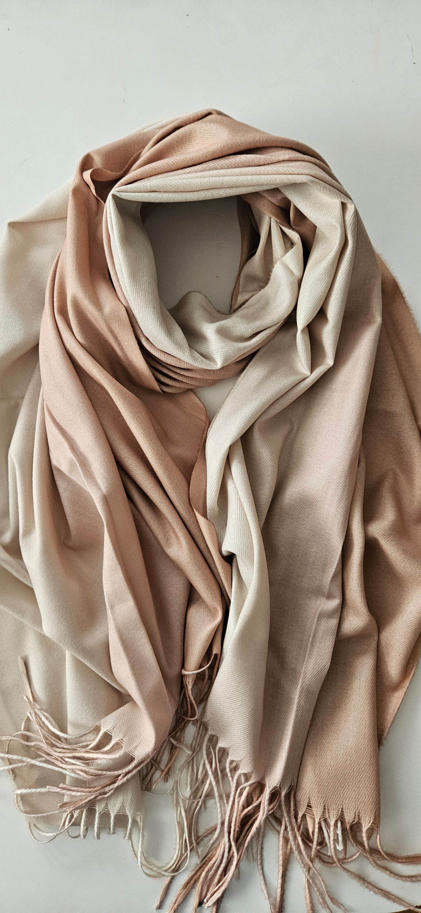 Beige two-toned scarf with tassels on a light background