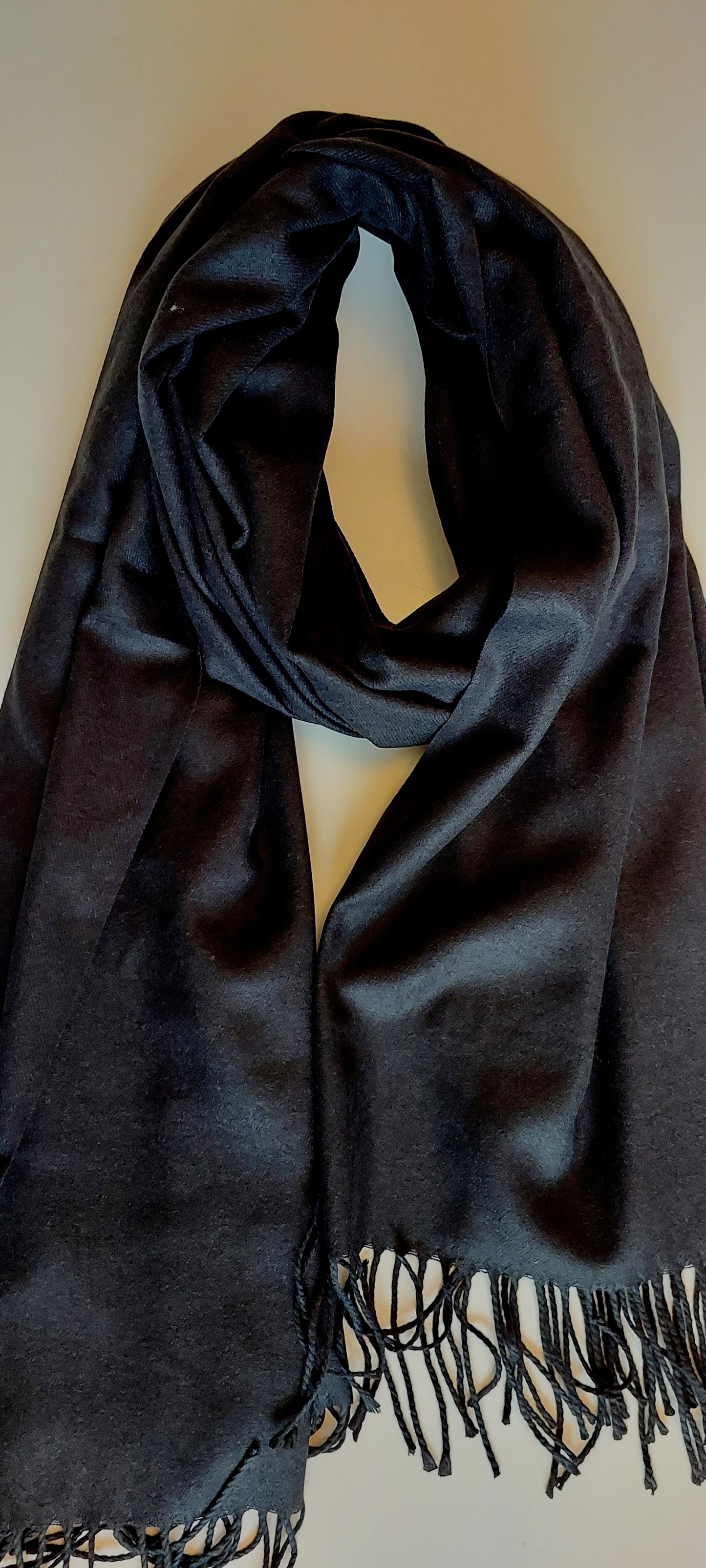 Black pashmina with fringe on a plain white background