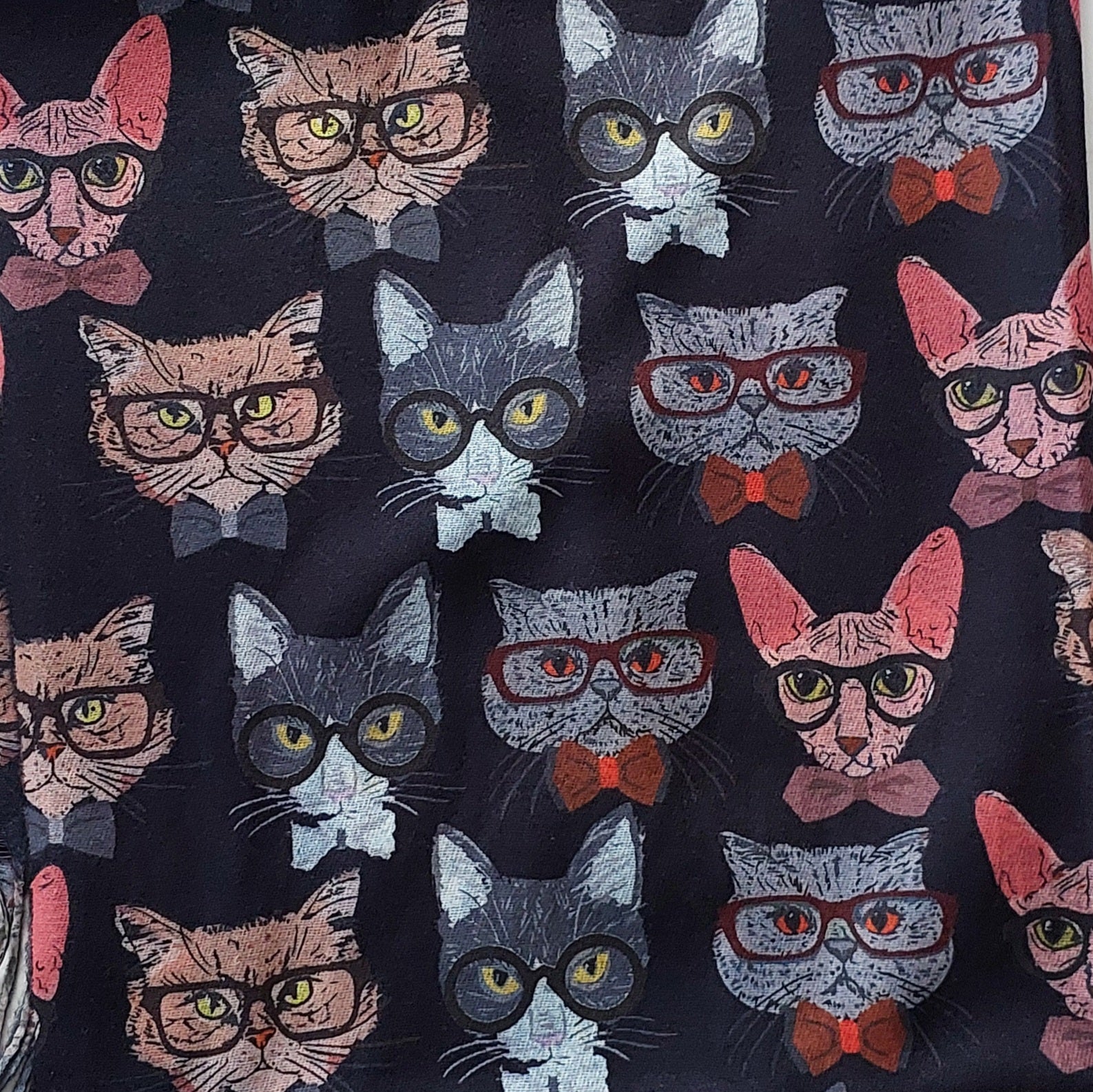 Pattern of cats wearing glasses and bow ties on a black background