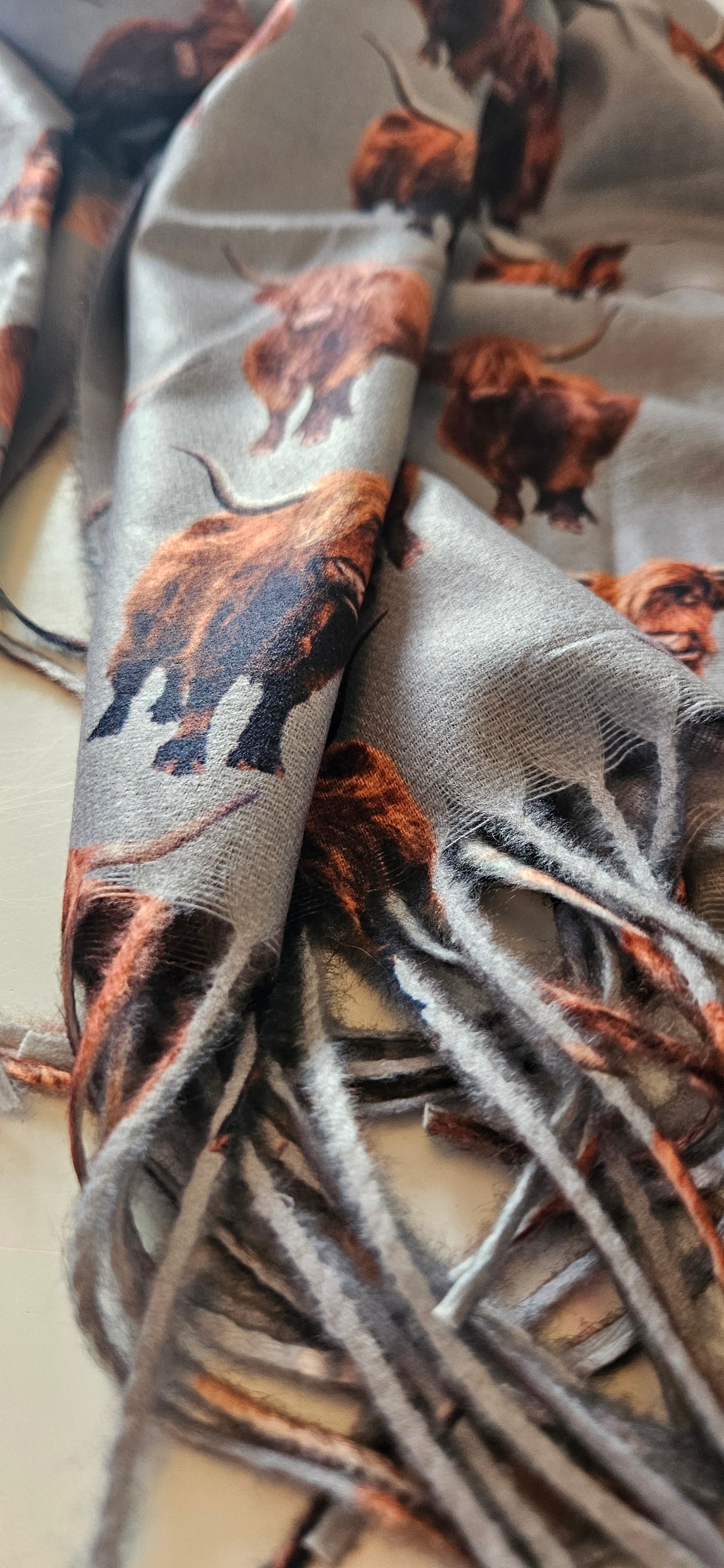 Close-up of a patterned scarf of brown and black Highland Cows on a white background