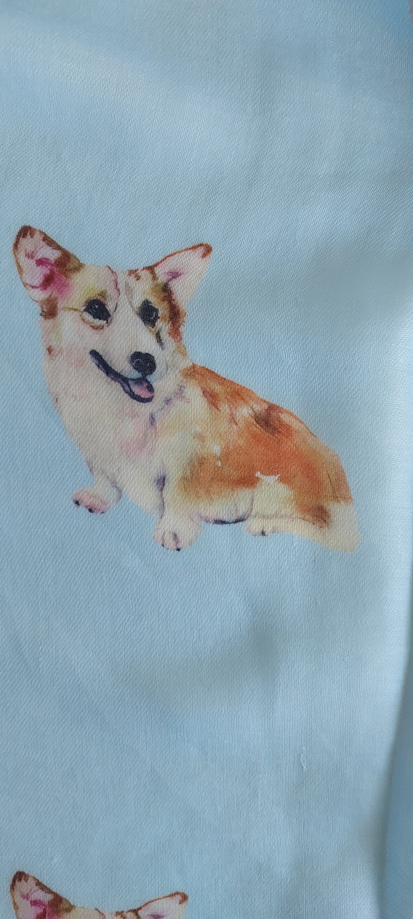 Close-up of scarf with a pattern of corgi dogs on a light blue background