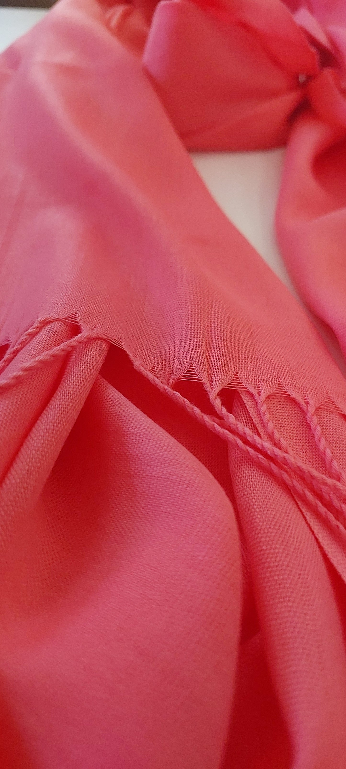 Close-up of coral pink Scarf with fringe edge