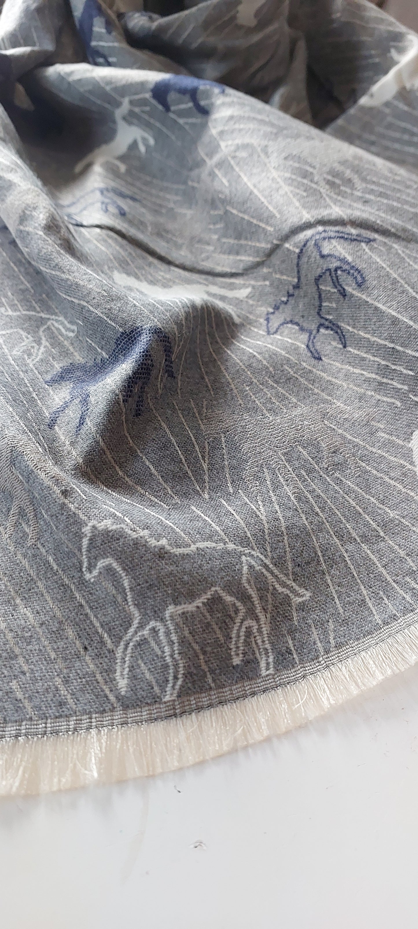 Close-up of a Grey Horse patterned scarf on a white background