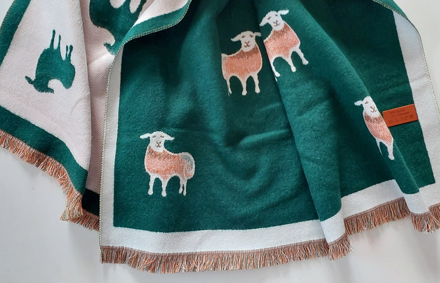 Green scarf with sheep designs on a white background