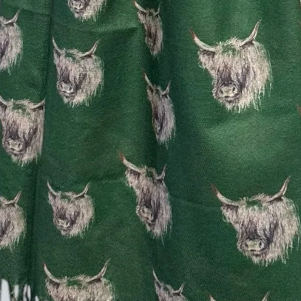 Green coloured pashmina with Monochromatic Highland cow heads on, with tassels peeking in at the bottom left corner