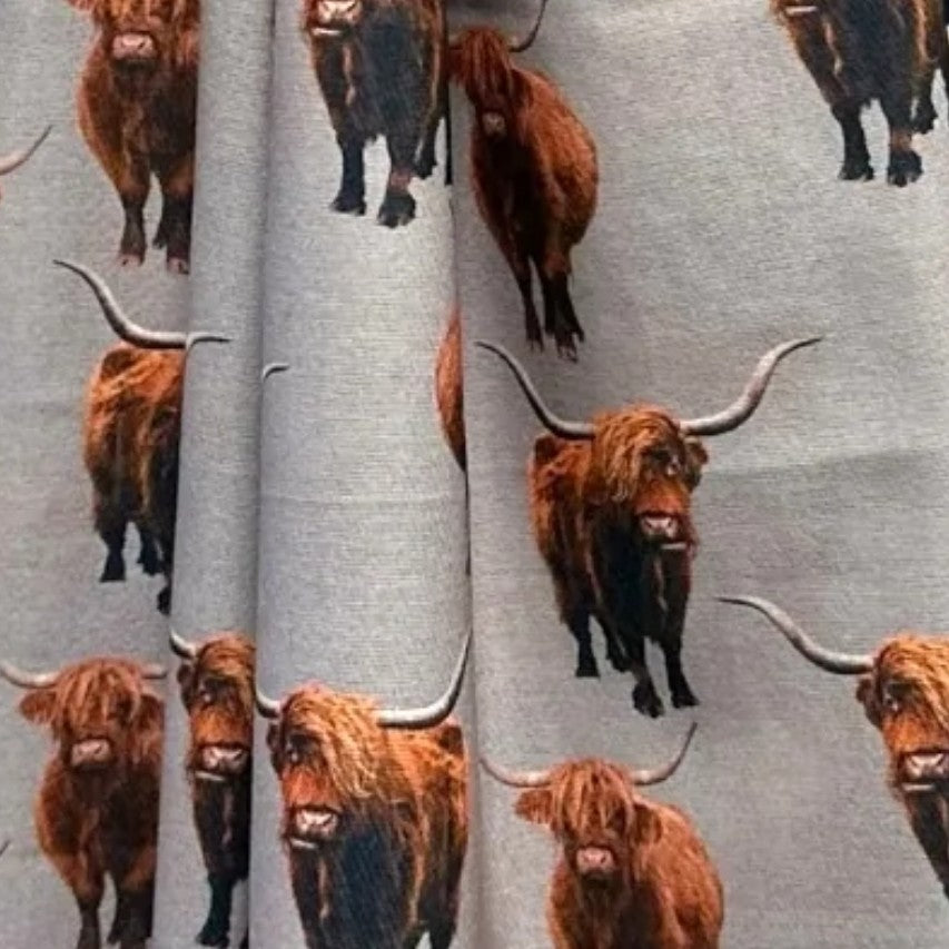 Grey coloured scarf fabric folded with full coloured Highland Cows printed all over it