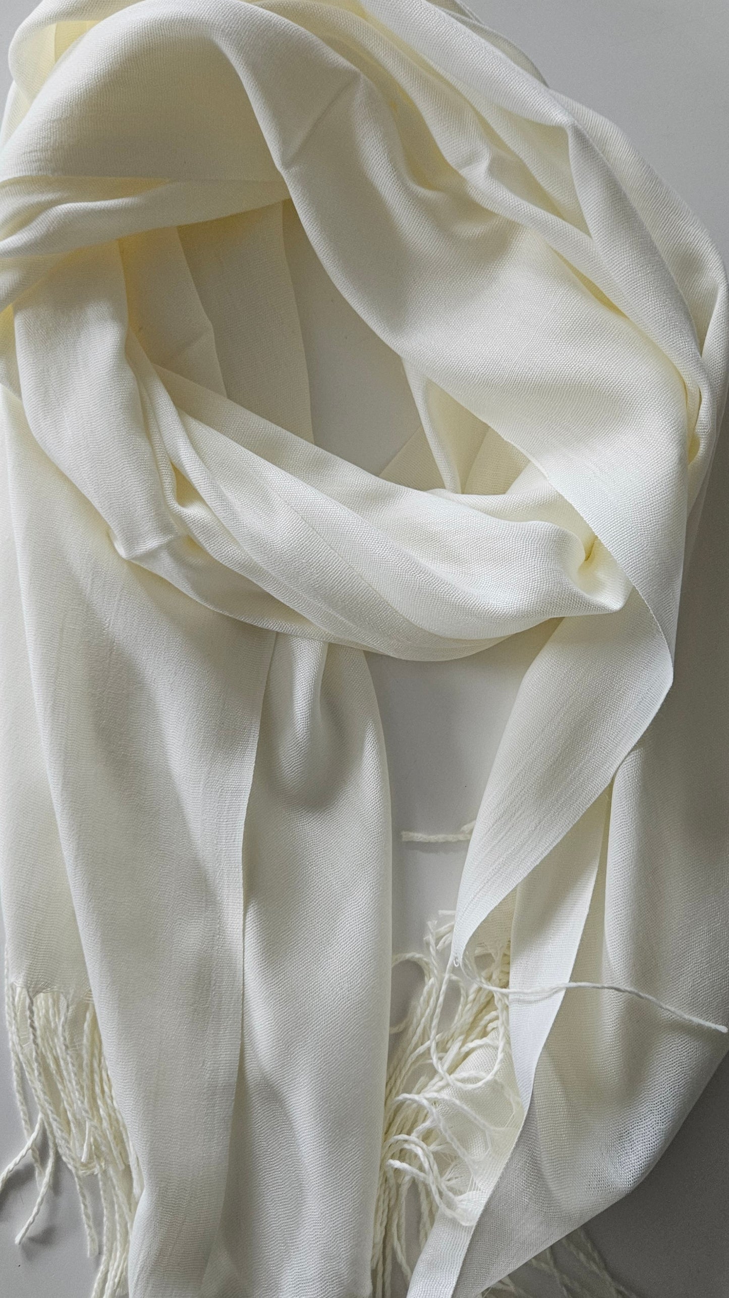 Ivory scarf with fringes on a white background
