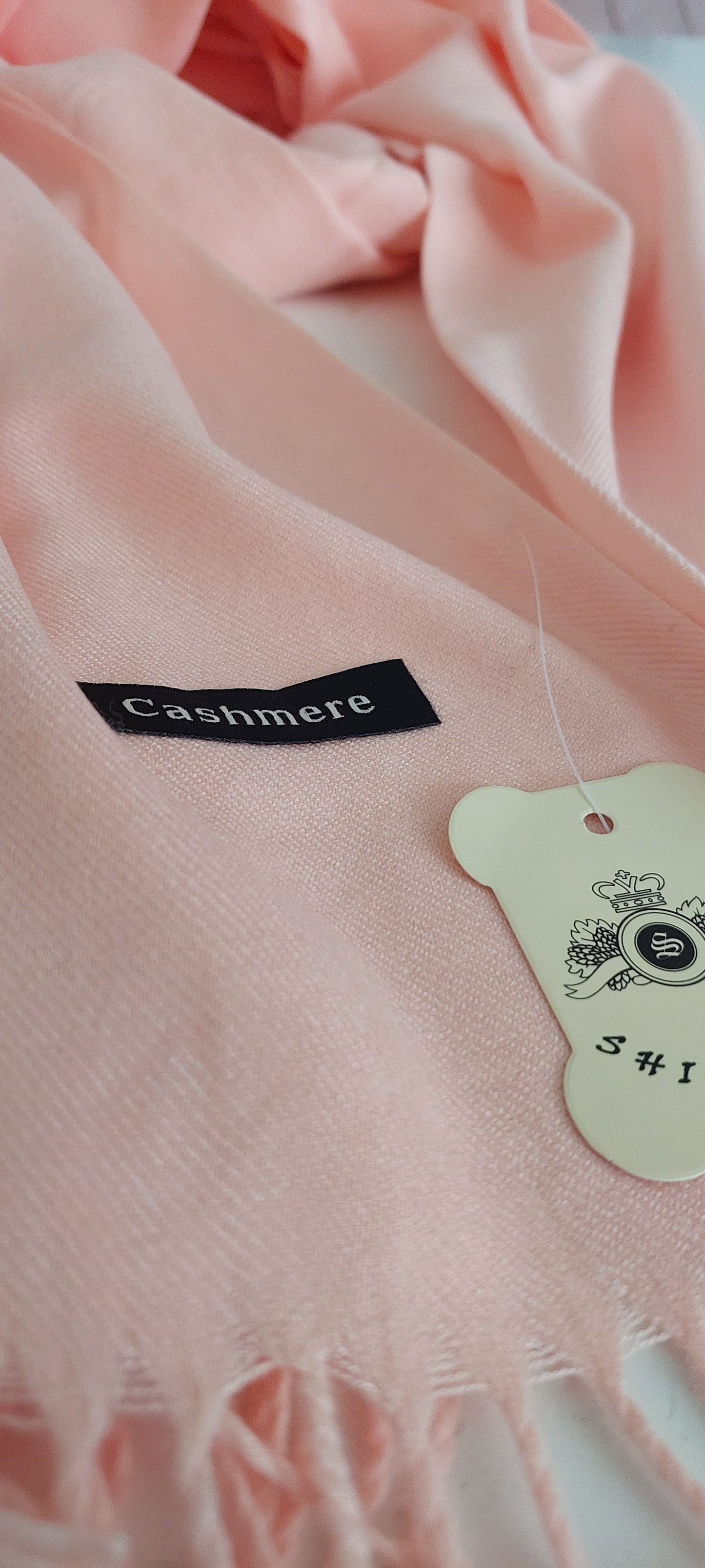 Close-up of a pink pashmina with a Cashmere label on a blurred background