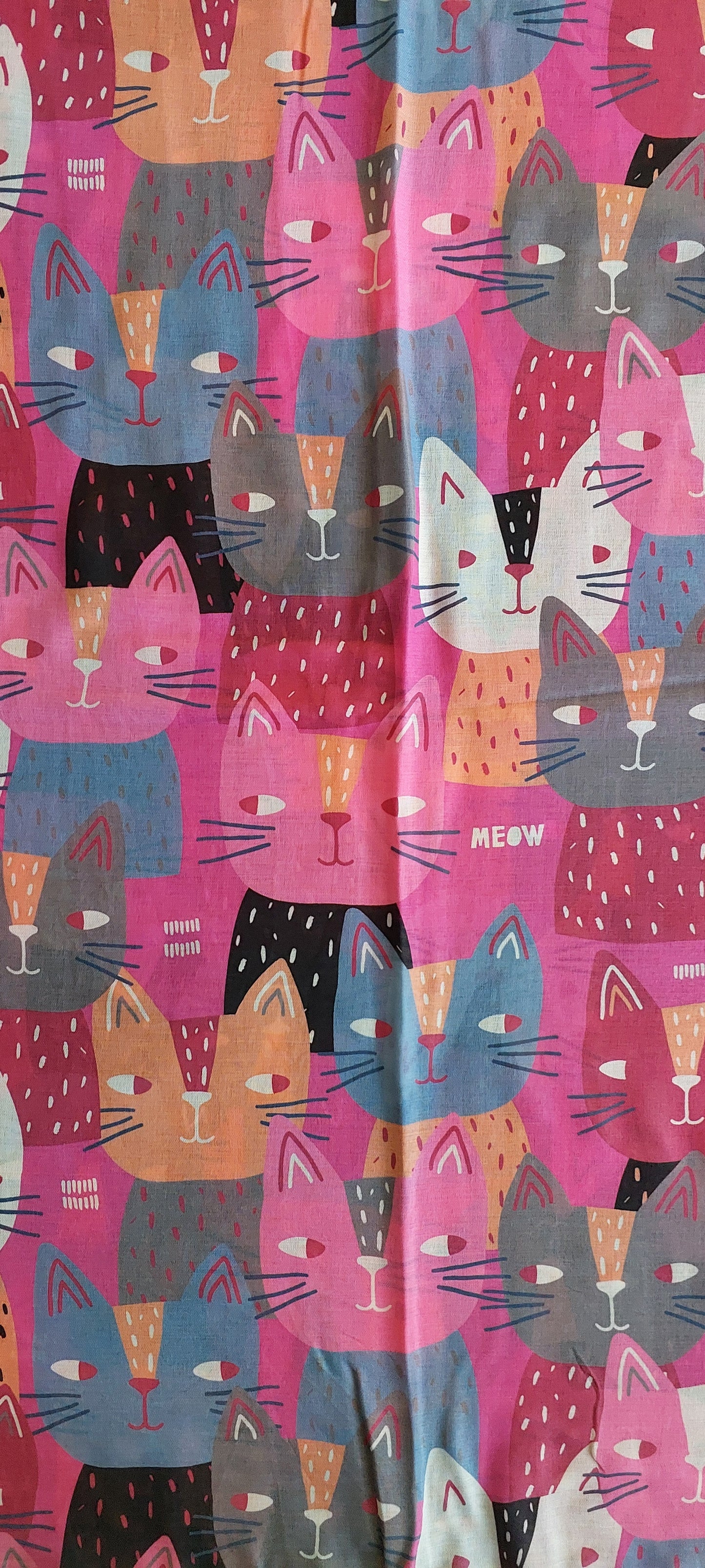 Patterned scarf with colourful cat faces making bombastic side eye look on a pink background