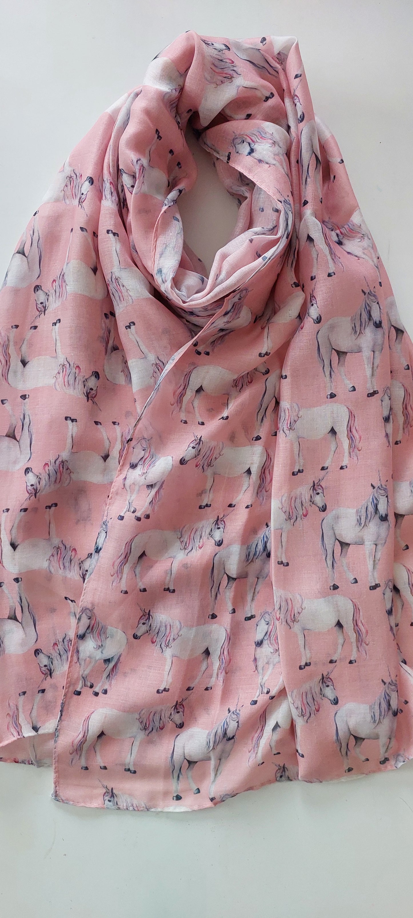 Pink scarf with a unicorn pattern on a white background