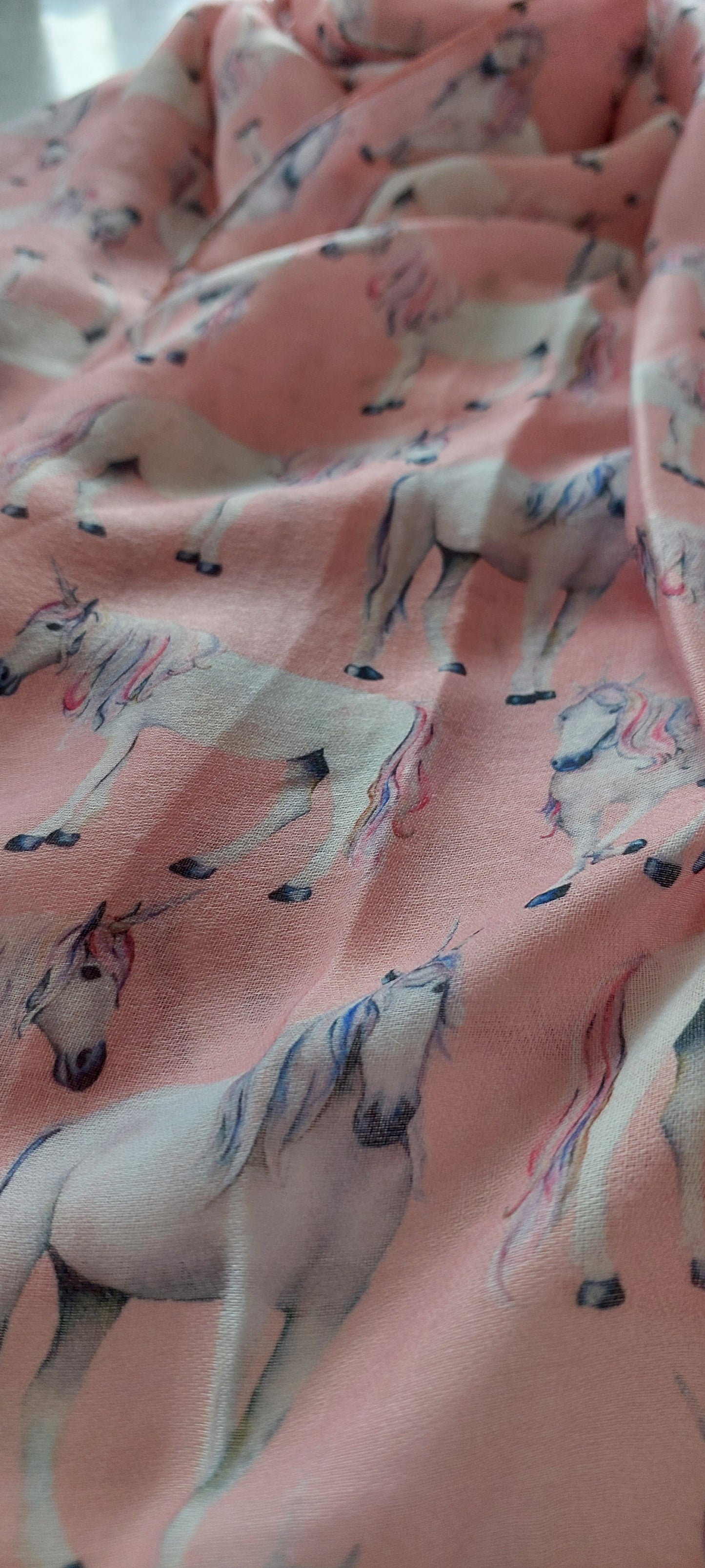 Close-up of pink scarf with unicorn pattern