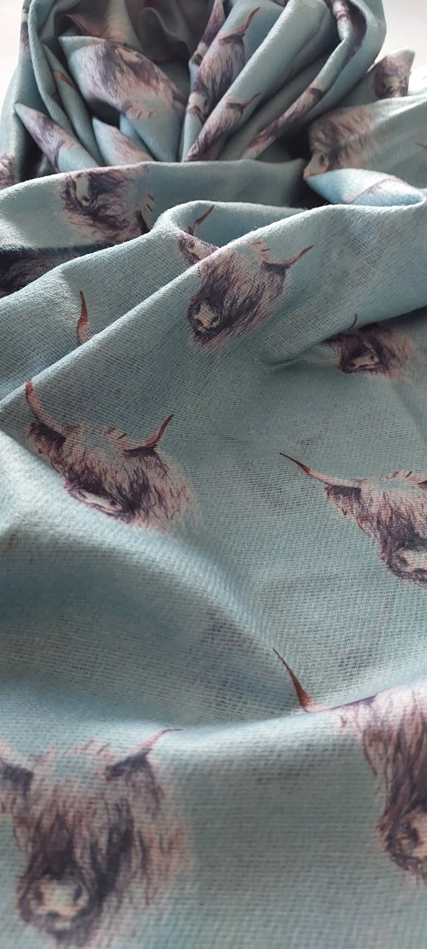 Pashmina with black and white highland cow print on a white background