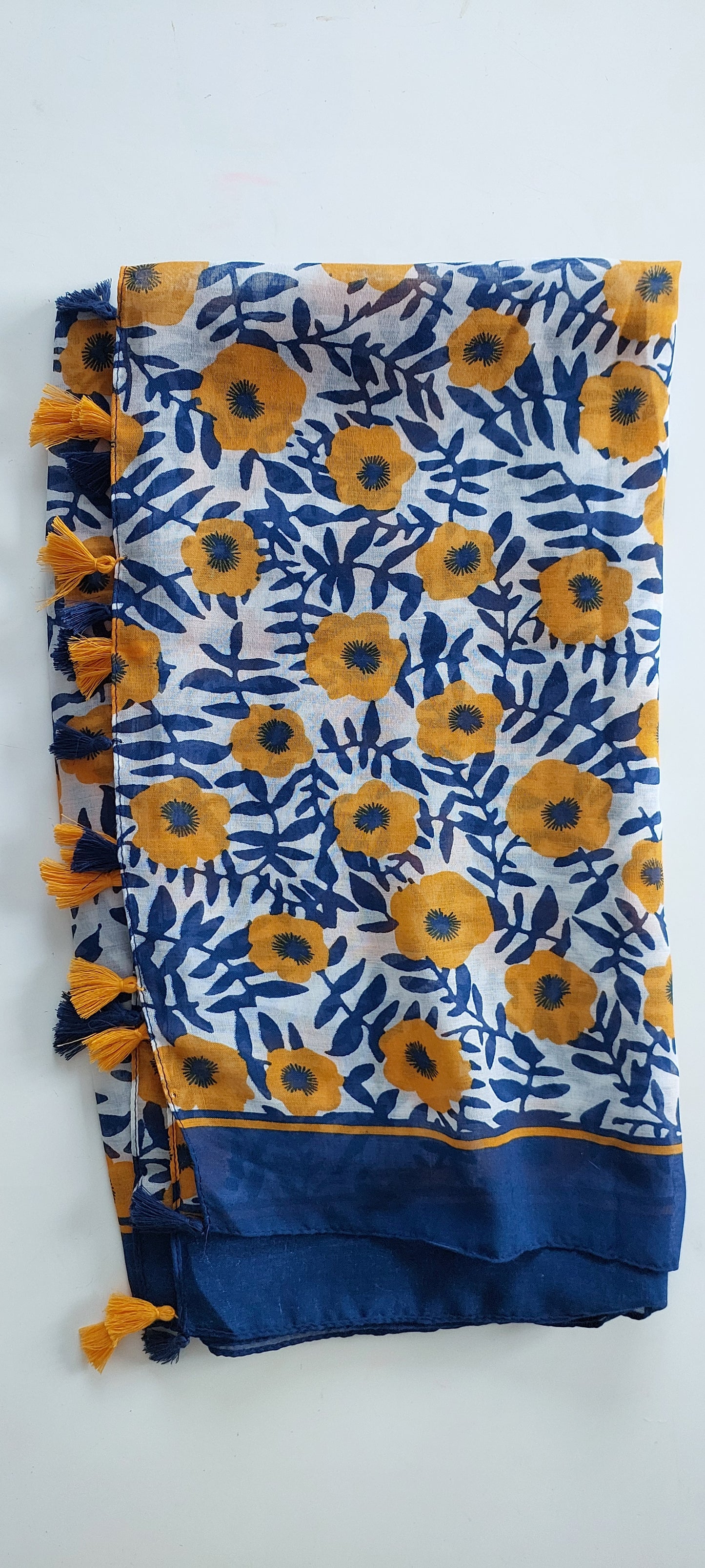 Blue and yellow floral patterned scarf with tassels on a white background