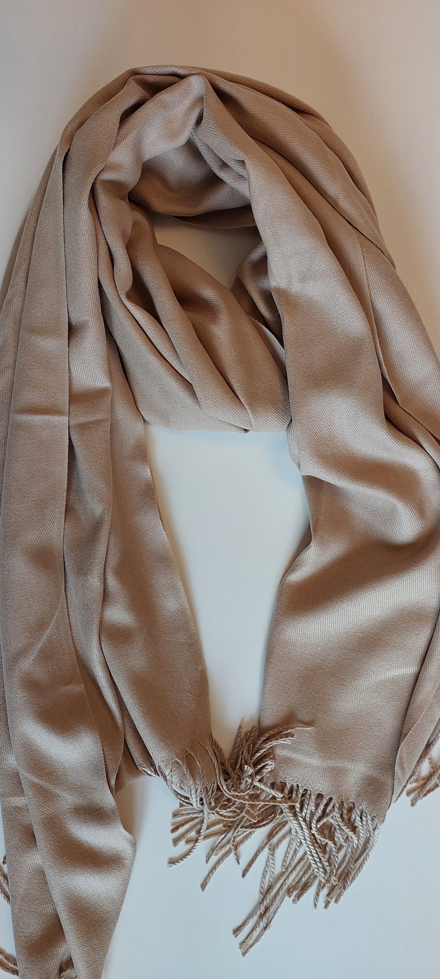 Beige scarf with fringes on a white background