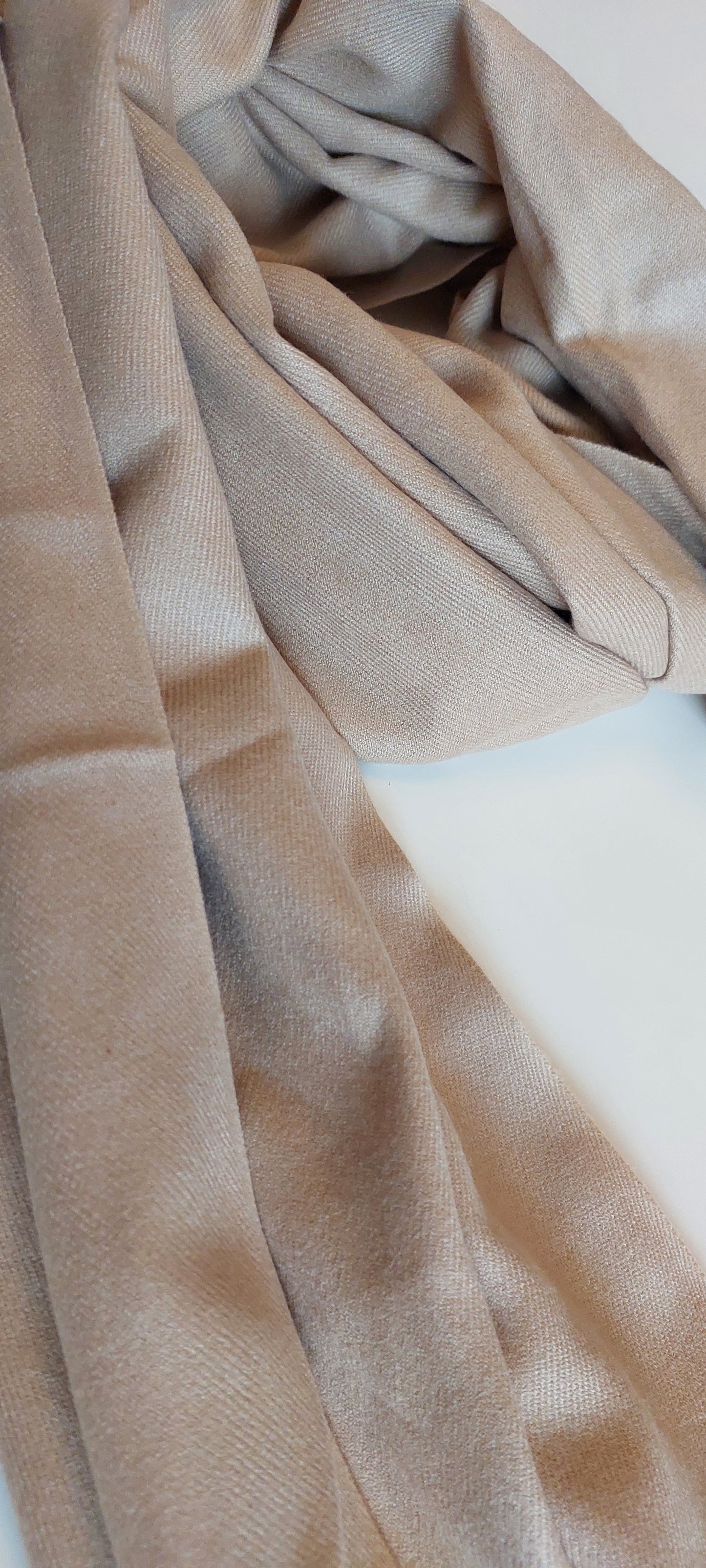 Close-up of beige pashmina with a soft texture on a light background