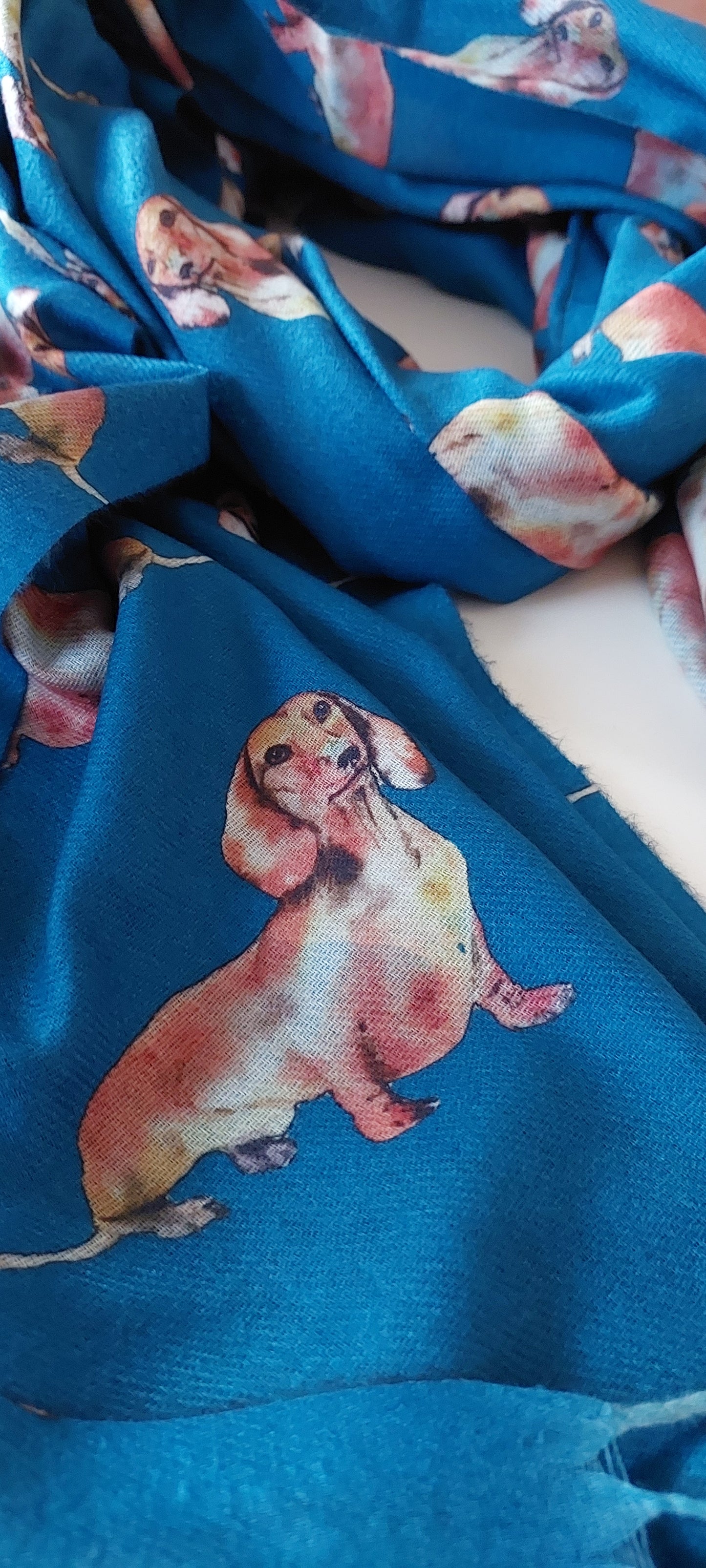 Close-up of teal pashmina with dachshund dog illustrations