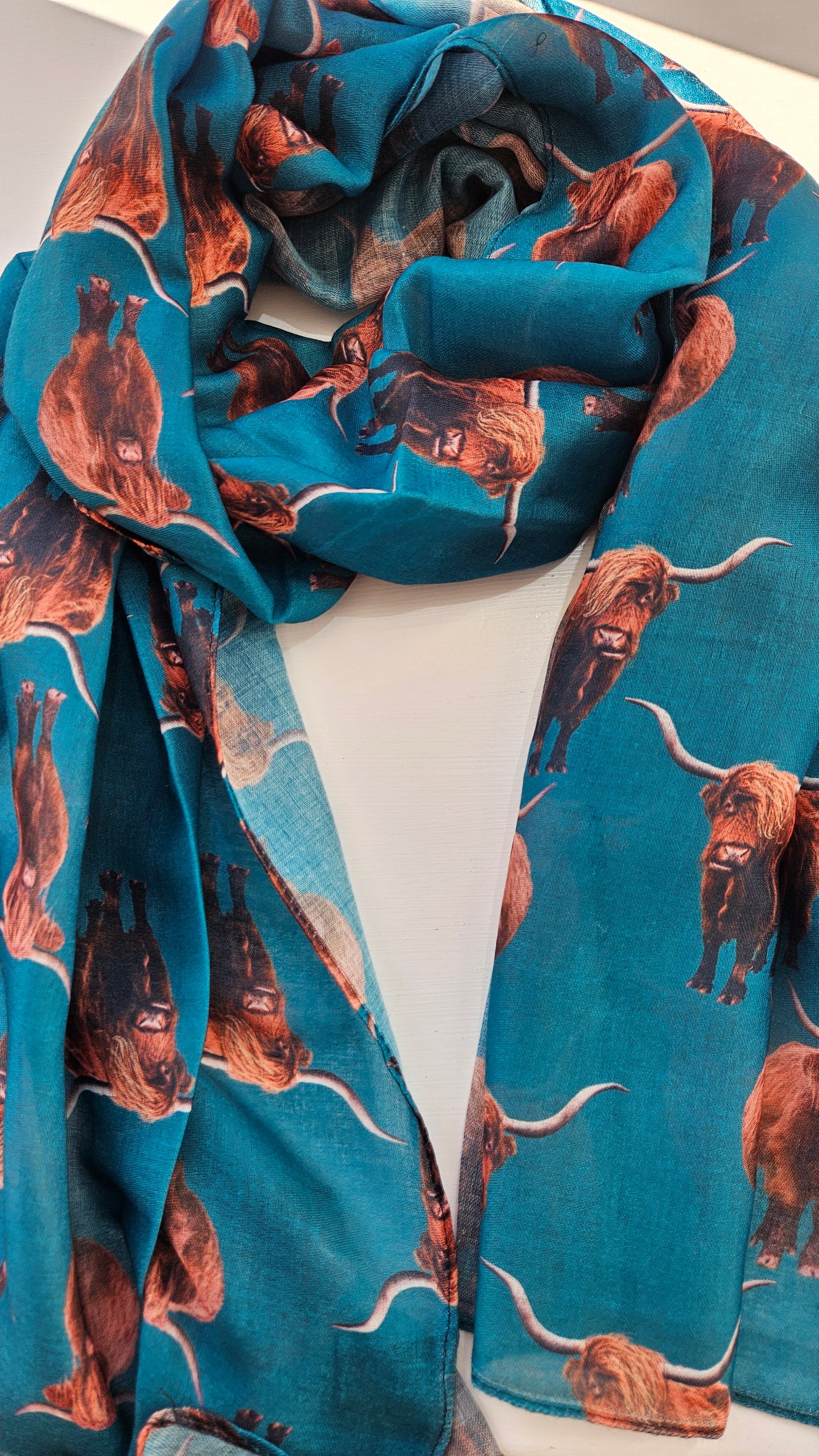 Teal Scarf with highland cow pattern on a white background