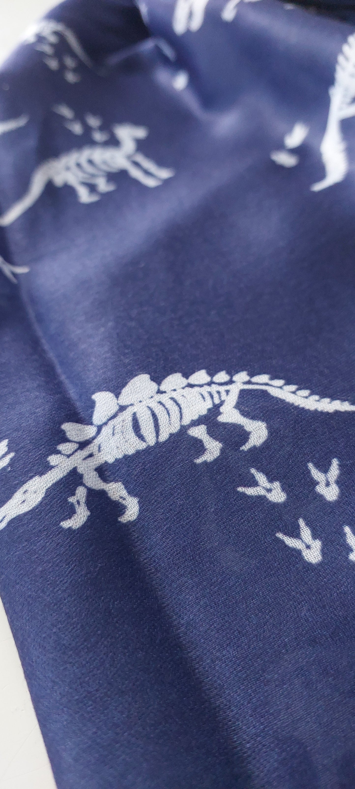 Navy blue scarf with white triceratops dinosaur skeleton patterns