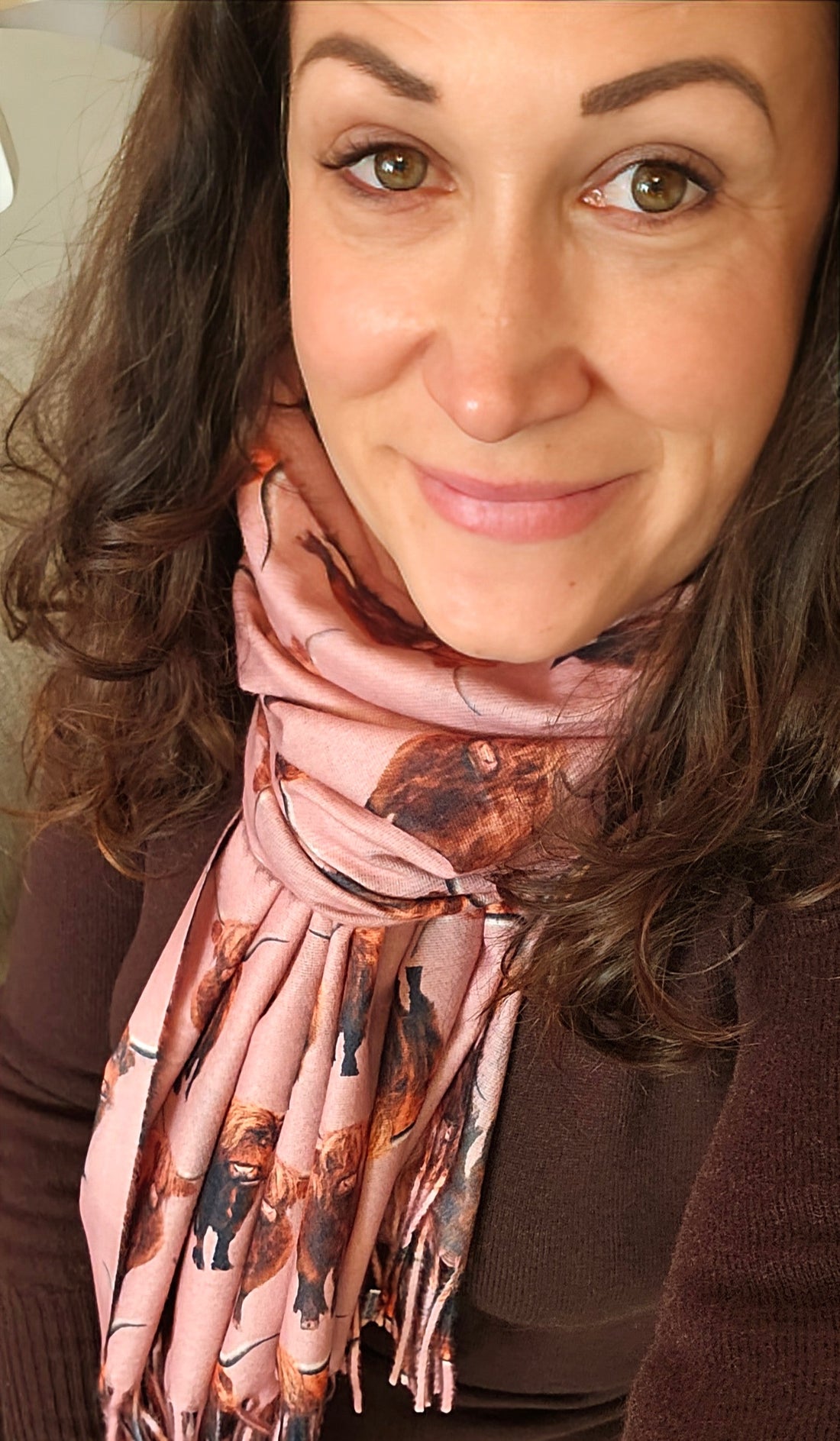 Founder of Shimena wearing a pink Highland Cow Pashmina with a brown cashmere dress