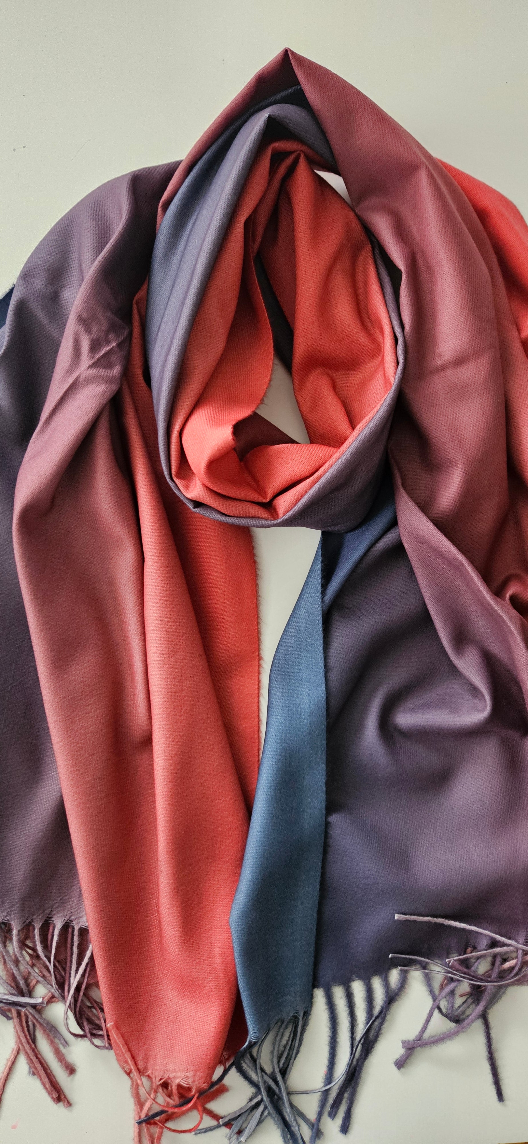 Folded scarf with shades of navy and burnt orange on a white background