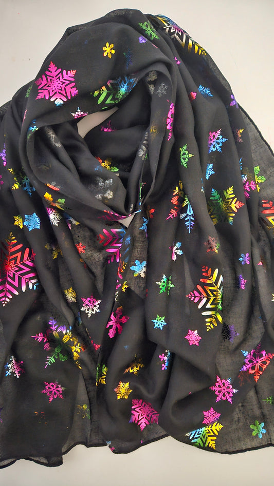 Black scarf with metallic colourful snowflake patterns on a white background