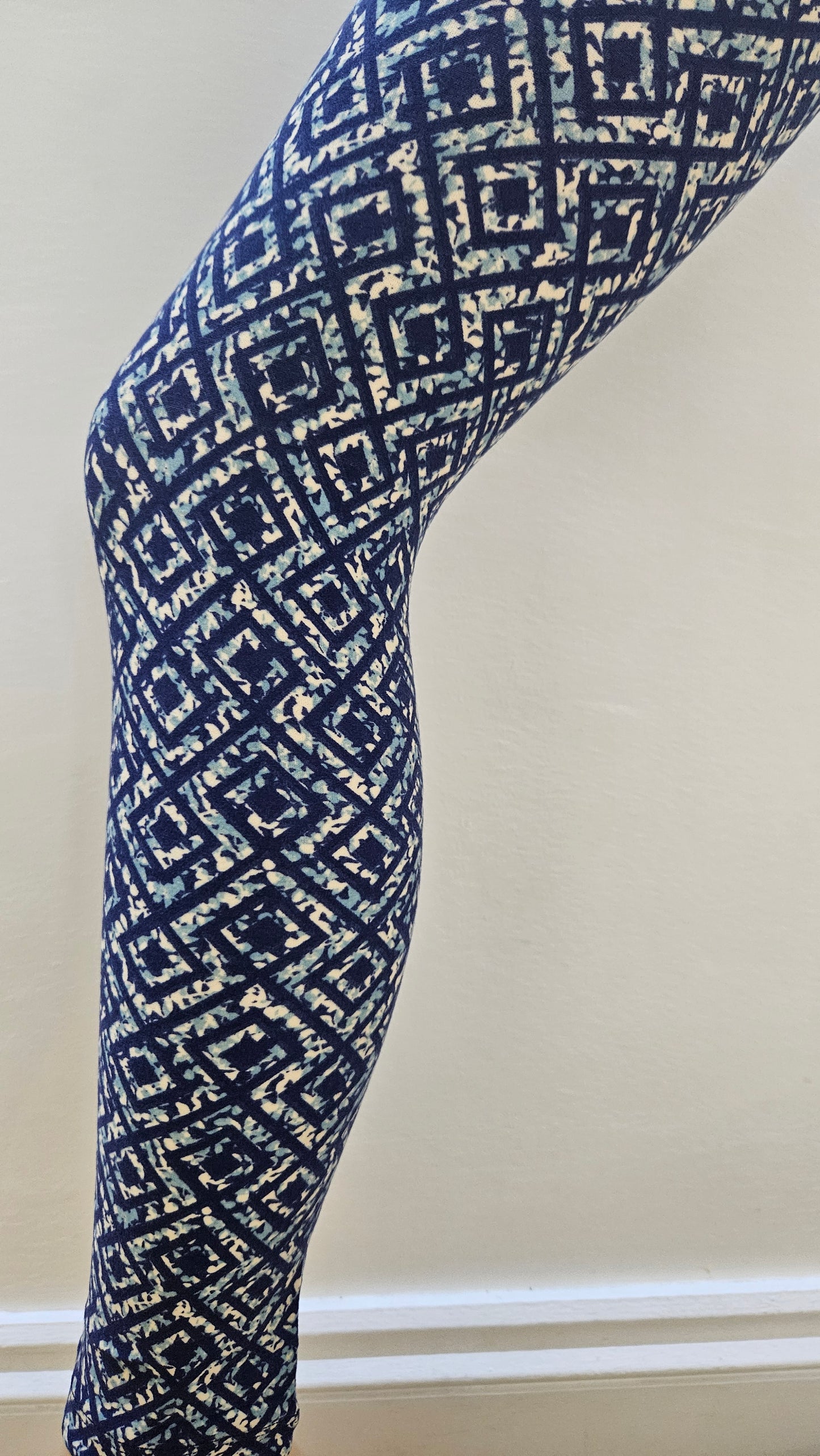 Blue and white patterned fabric modelled infront of a white surface
