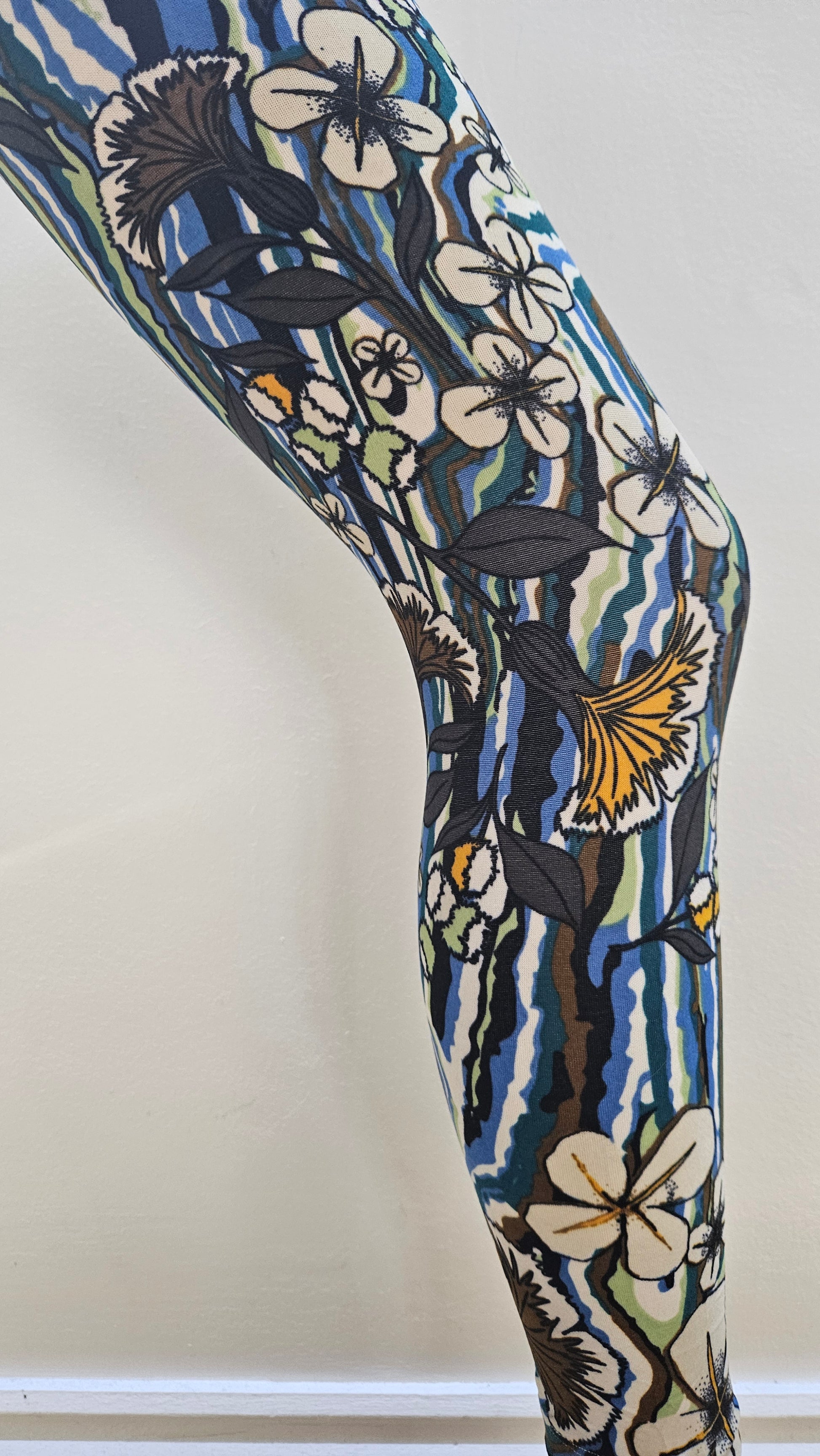 Floral-patterned leggings modelled infront of a white surface