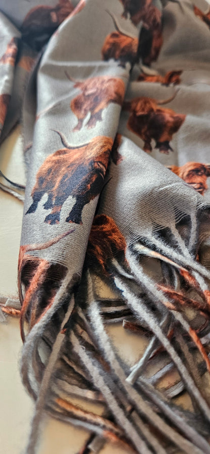 Close-up of a patterned scarf of brown and black Highland Cows on a white background