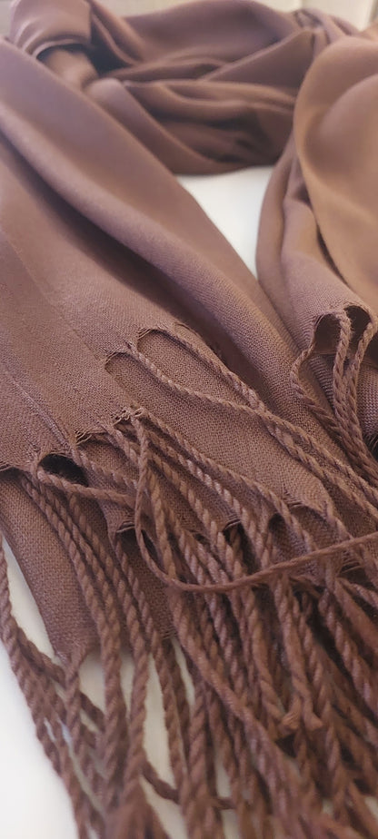 Close-up of a brown scarf with fringed edges on a white background