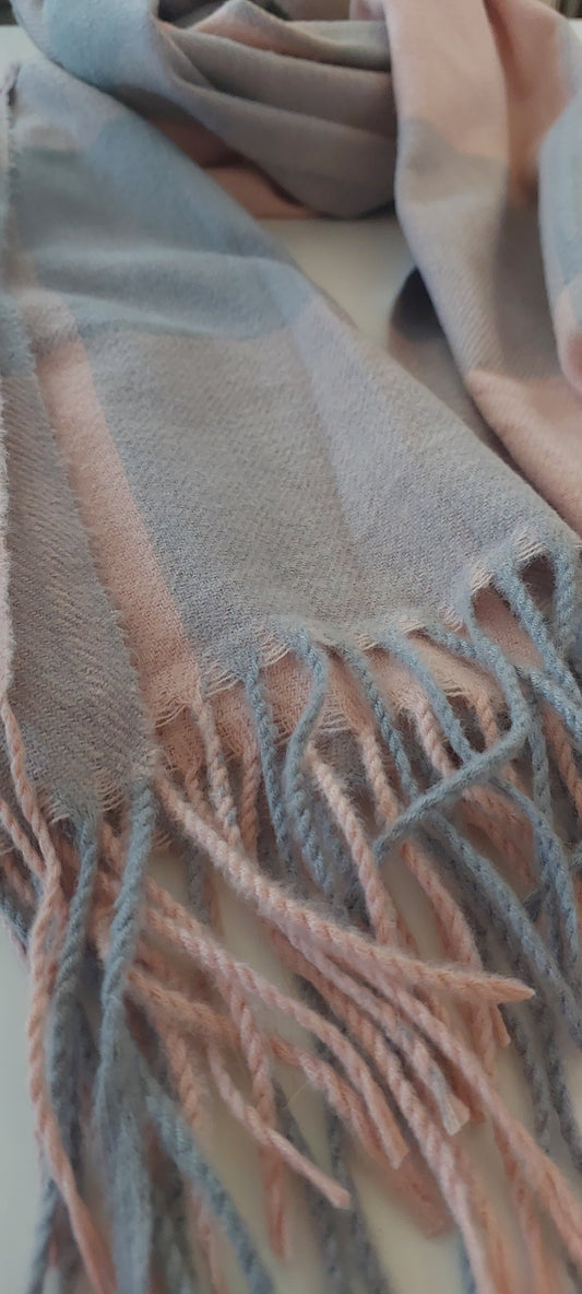 Close up image of baby pink and grey toned checkered scarf with tassels
