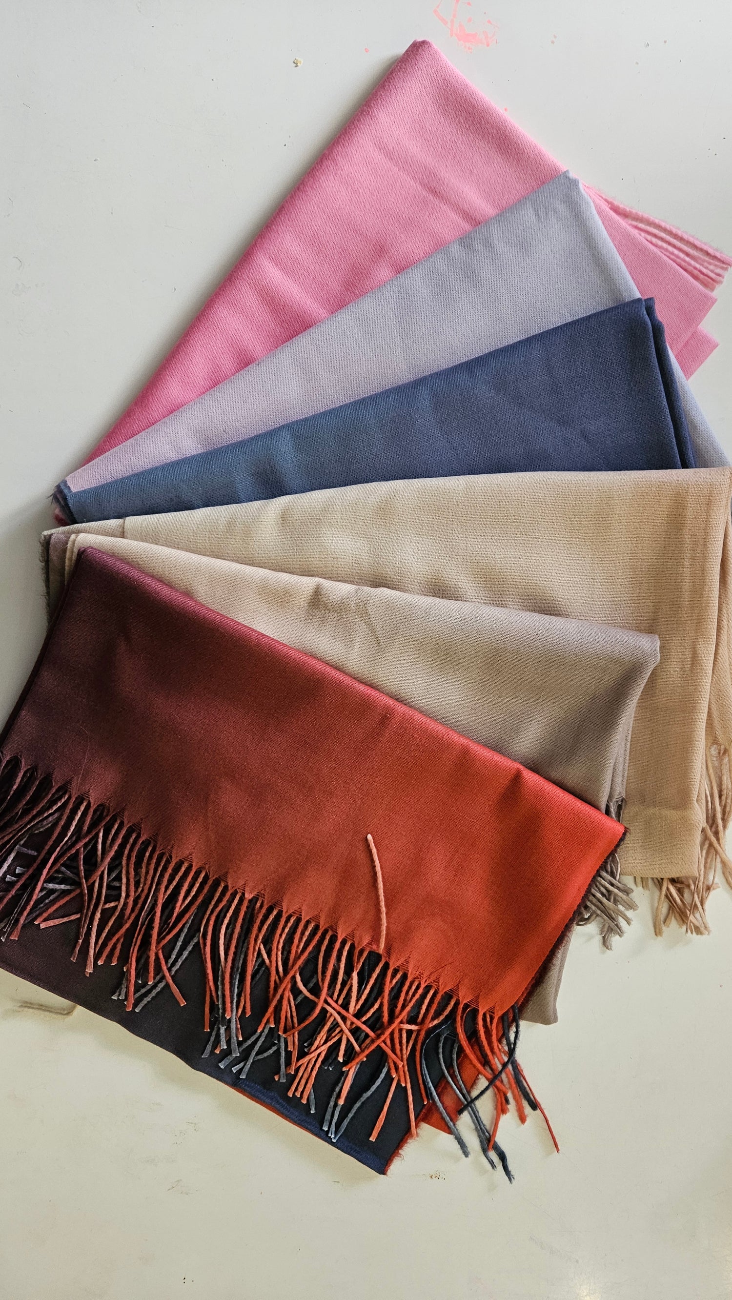 Array of two toned pashminas on a white background 