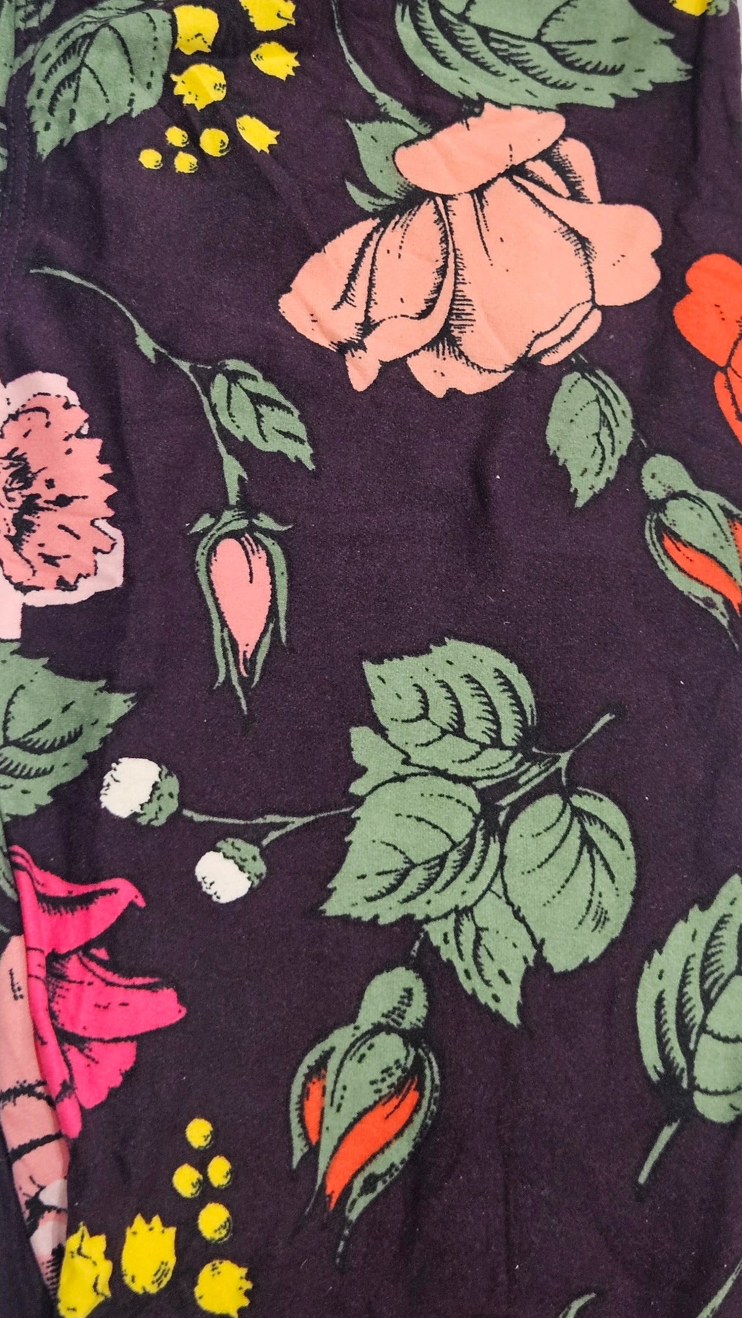 Floral patterned fabric with pink roses and green leaves on a dark background