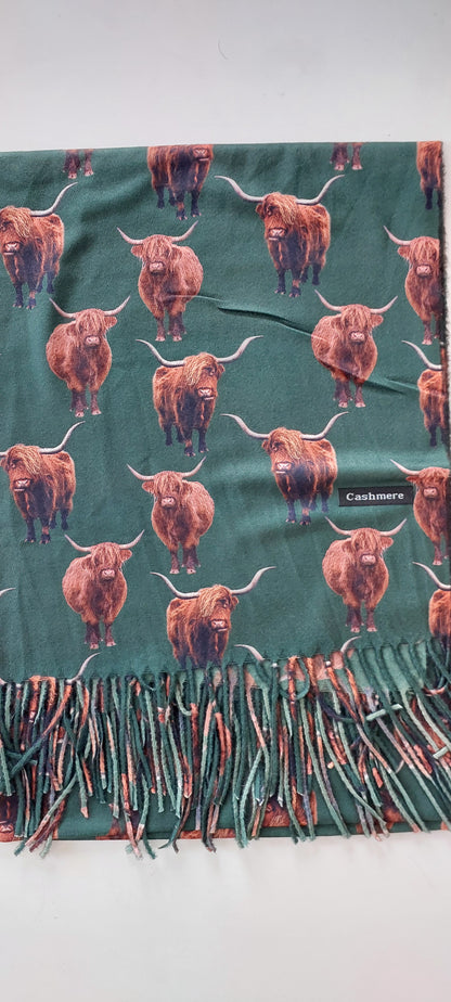 Green Scarf with highland cow pattern and cashmere label on a white background