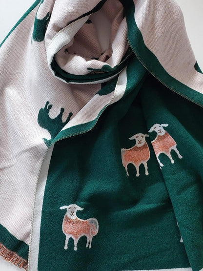 Green and white scarf with sheep designs on a white background