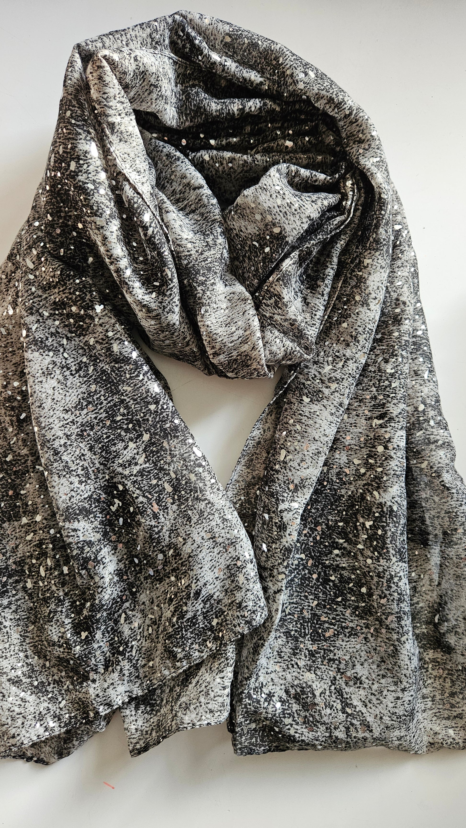 Grey scarf with silver glitter dots on a white background