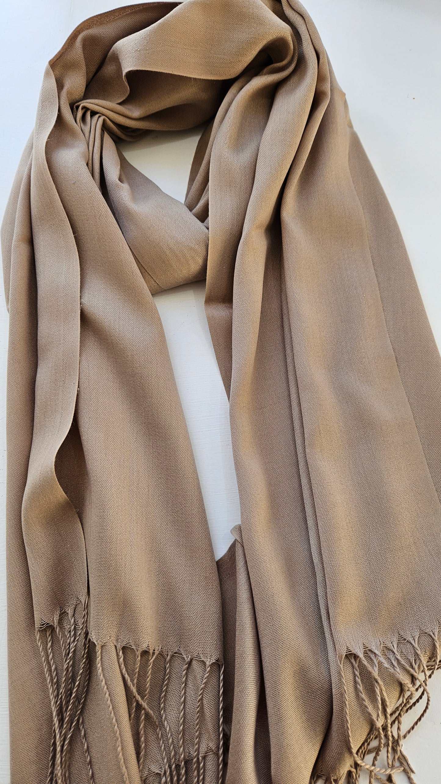 Light dusty brown scarf with fringes on a white background