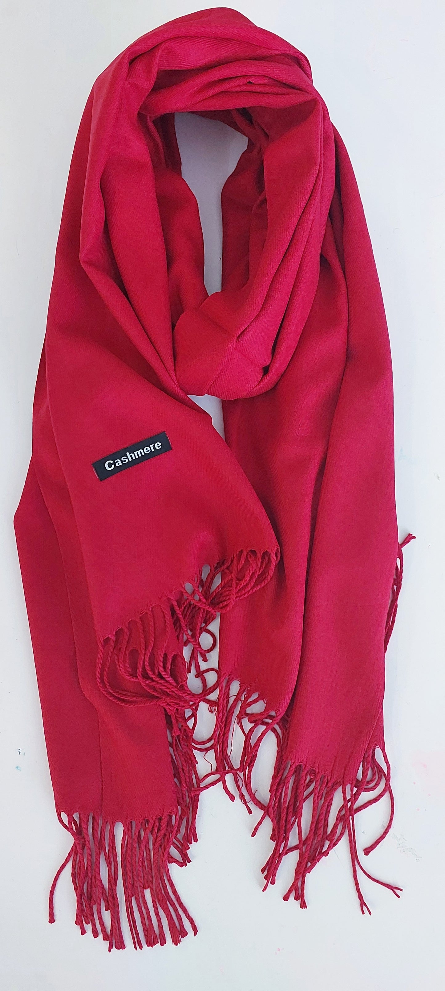 Red scarf with fringes and a visible cashmere label on a white background