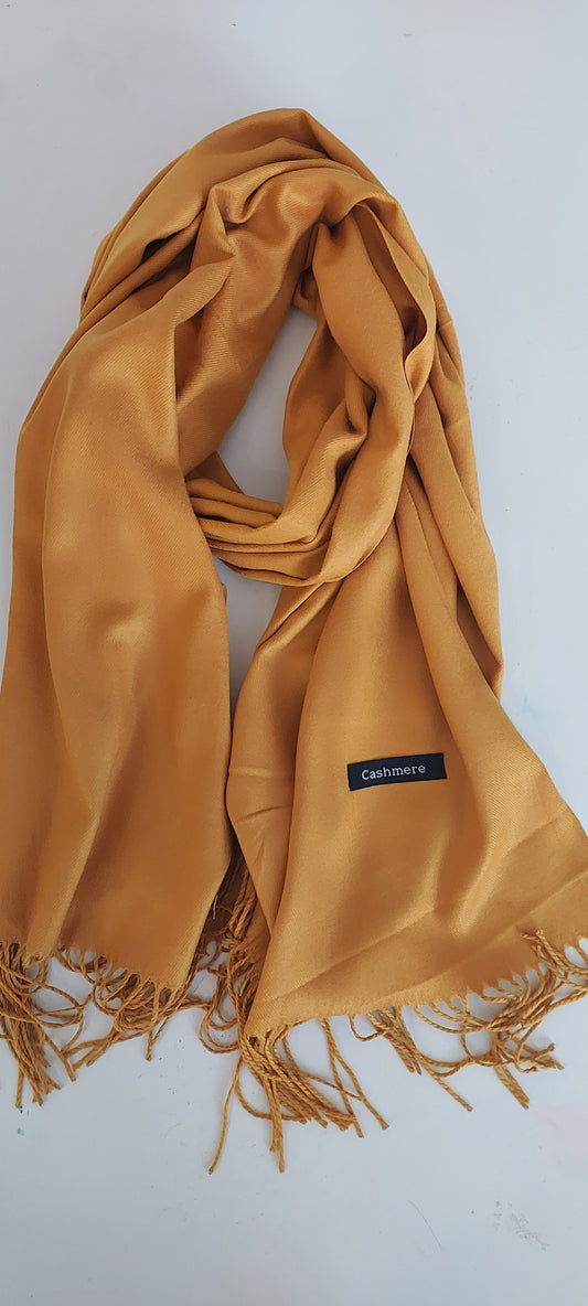 Mustard yellow scarf with fringes on a white background