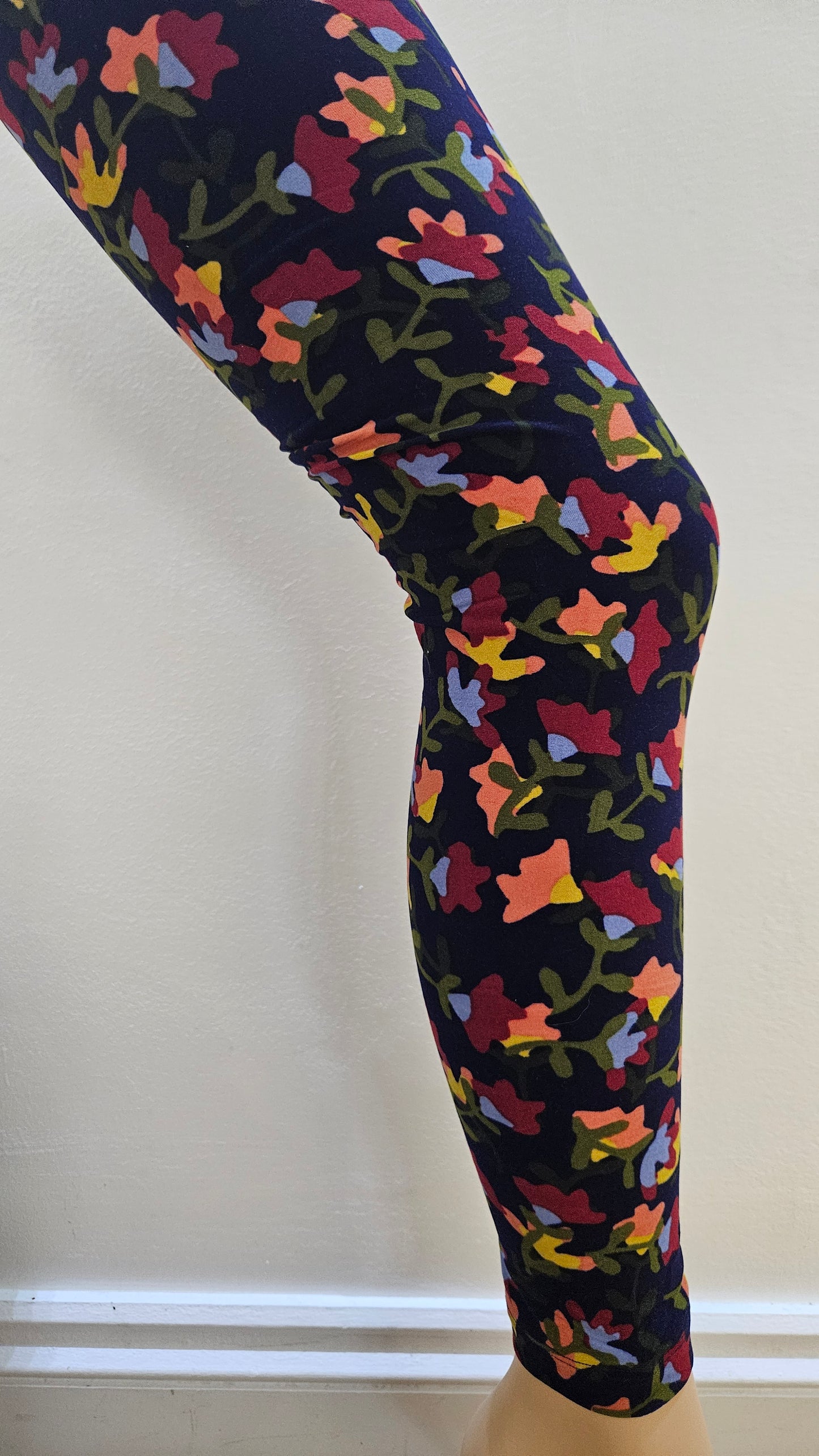 Colorful patterned leggings on a mannequin against a white background