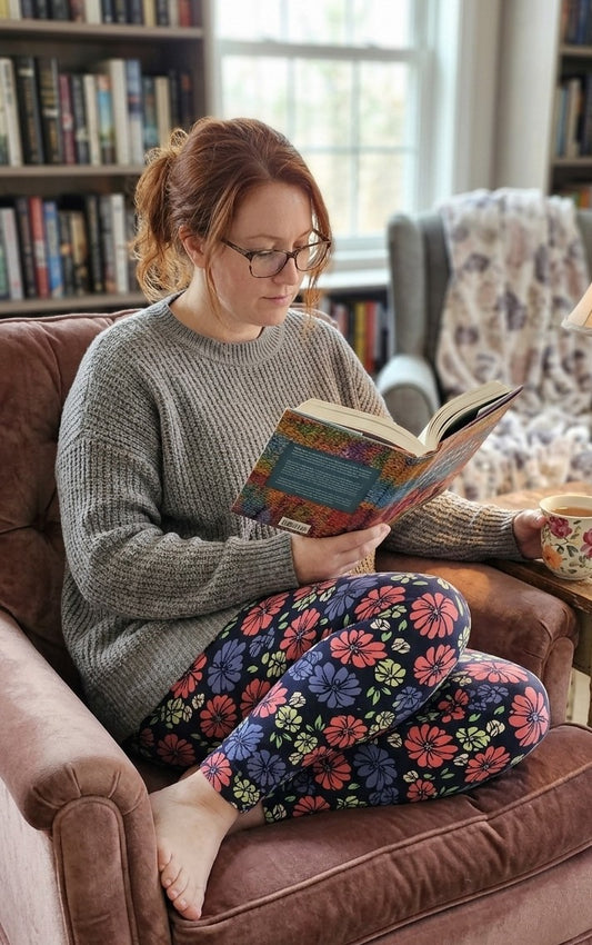 Woman reading a book on a couch in a cozy living room.