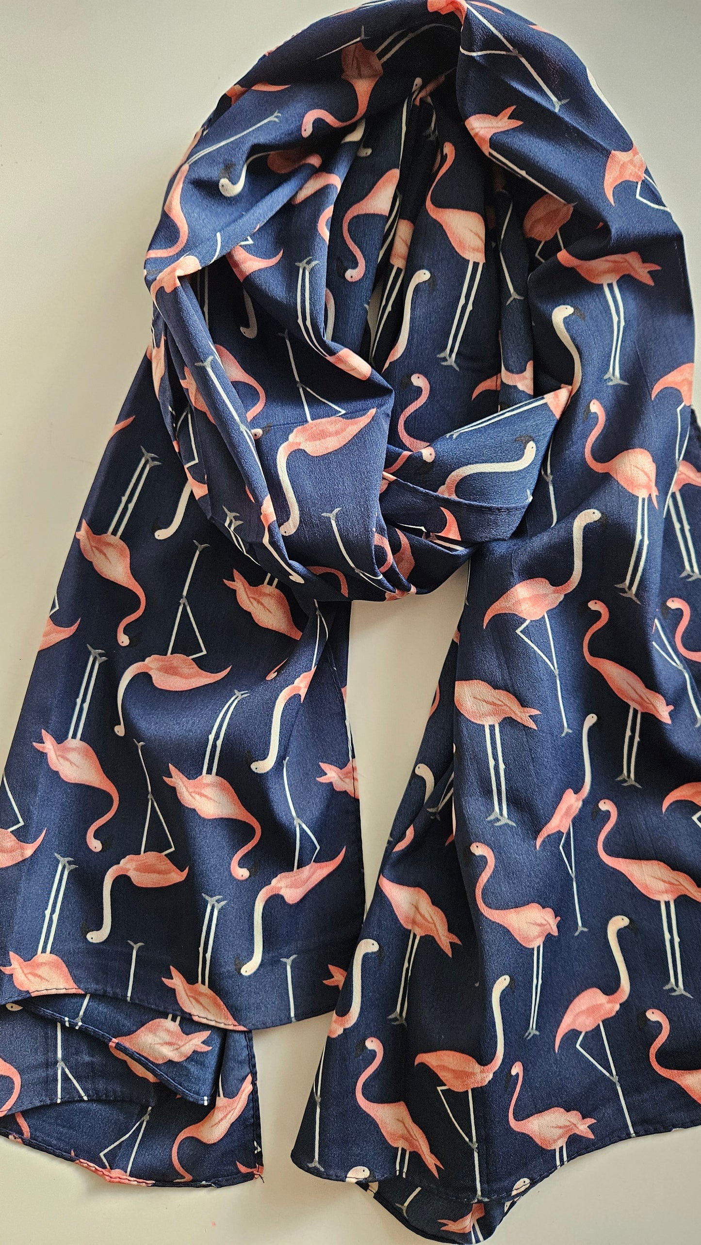 Navy blue scarf with pink flamingo pattern on a white background