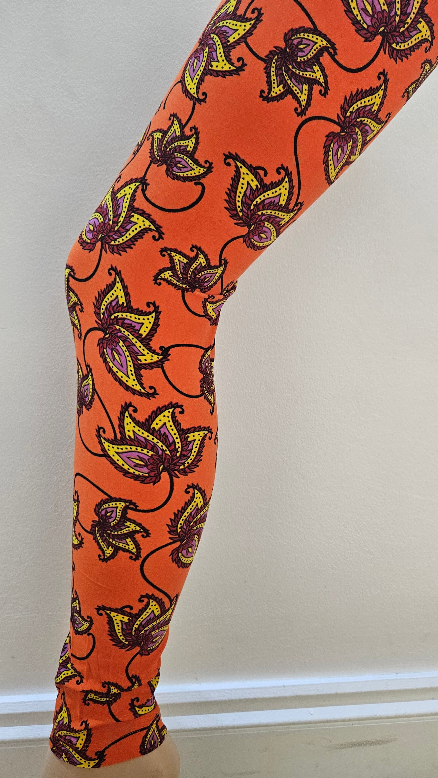 Orange leggings with floral pattern on a white background