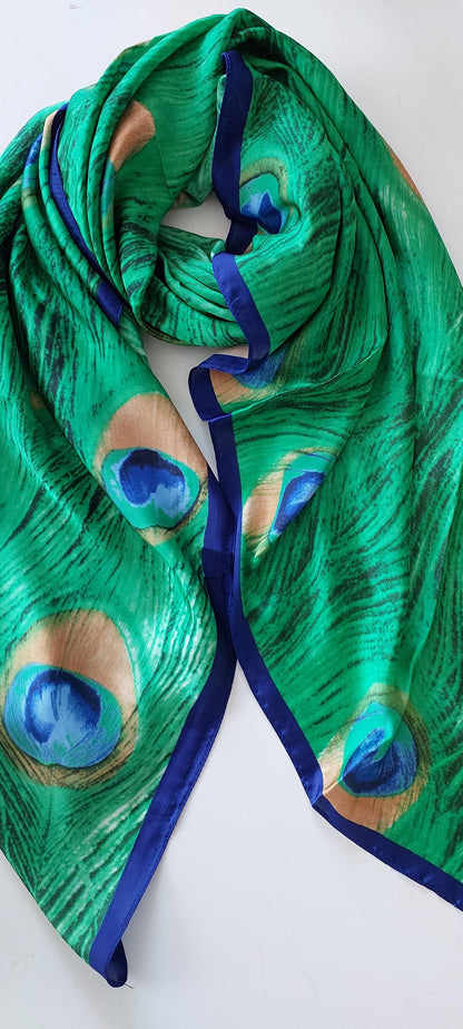 Green peacock feather patterned silky scarf on a white background