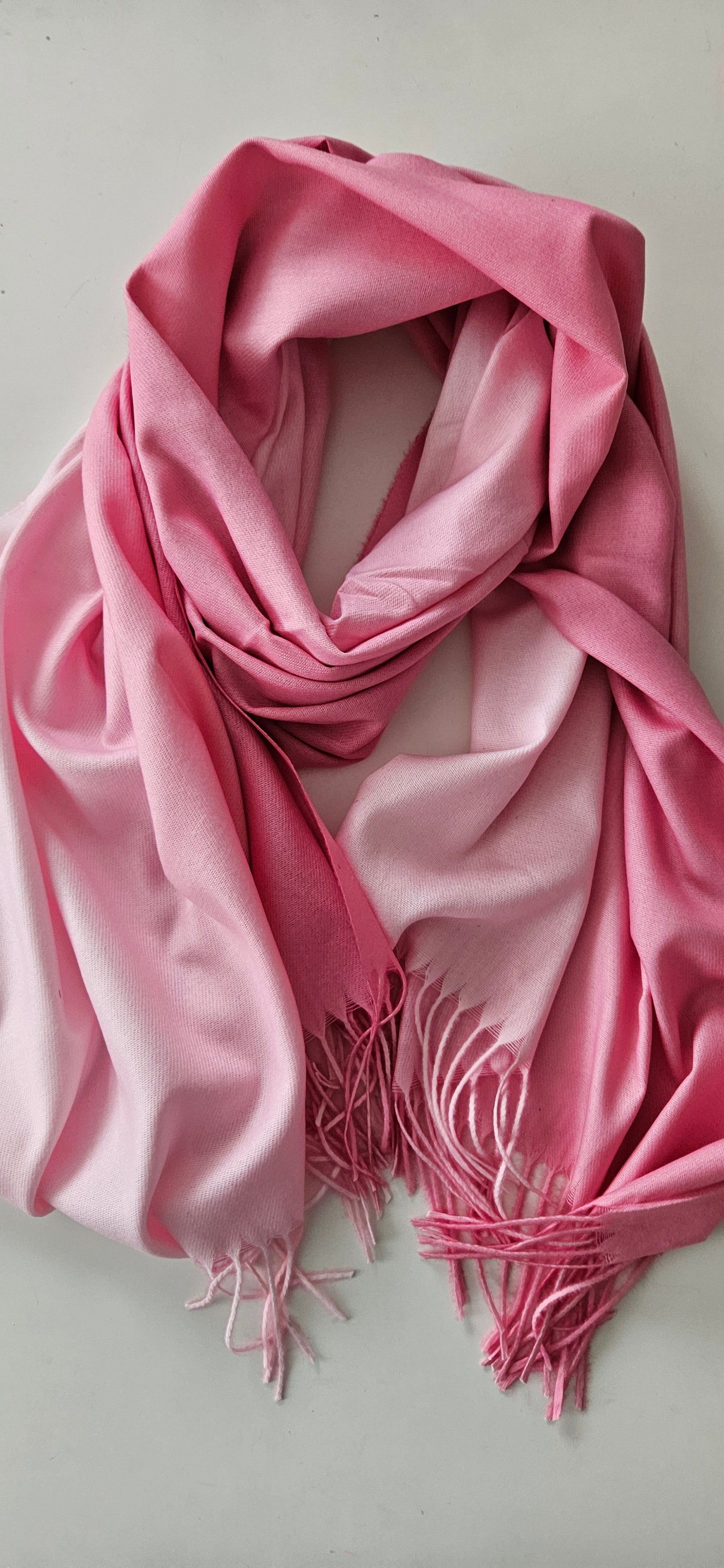 Pink two toned scarf with tassels on a white background