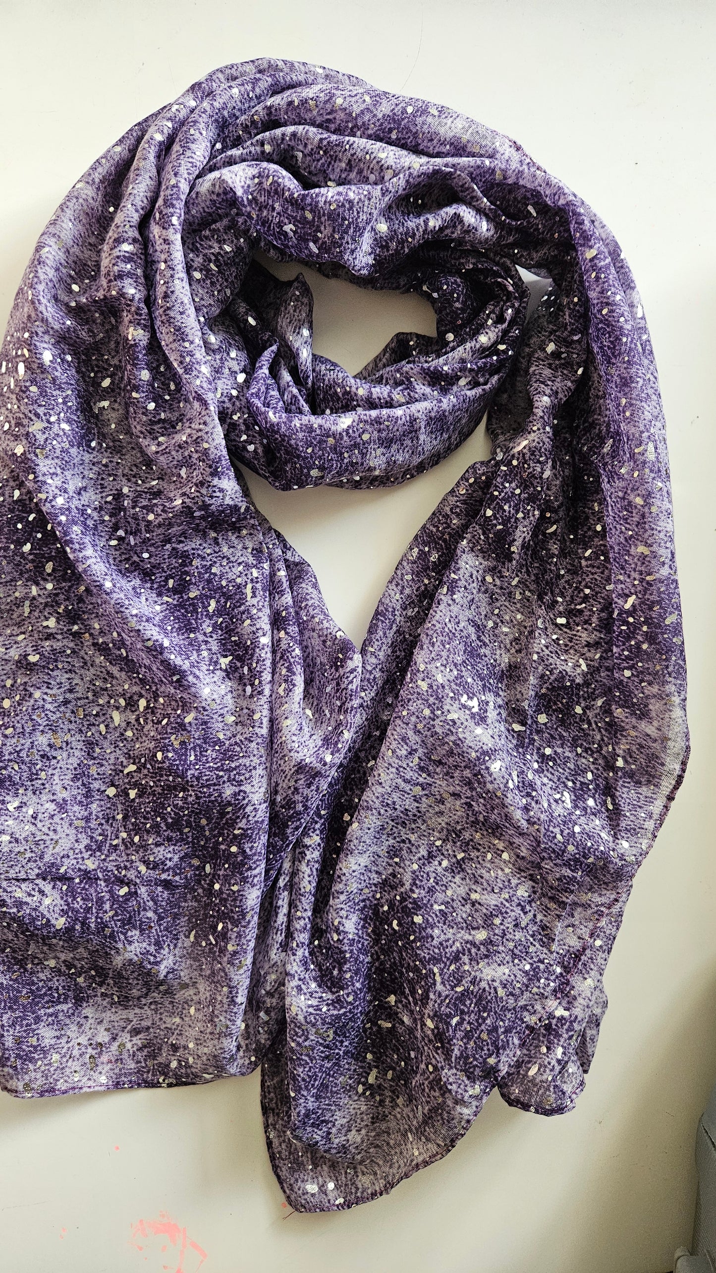 Purple textured scarf with silvery glitter dots on a light background