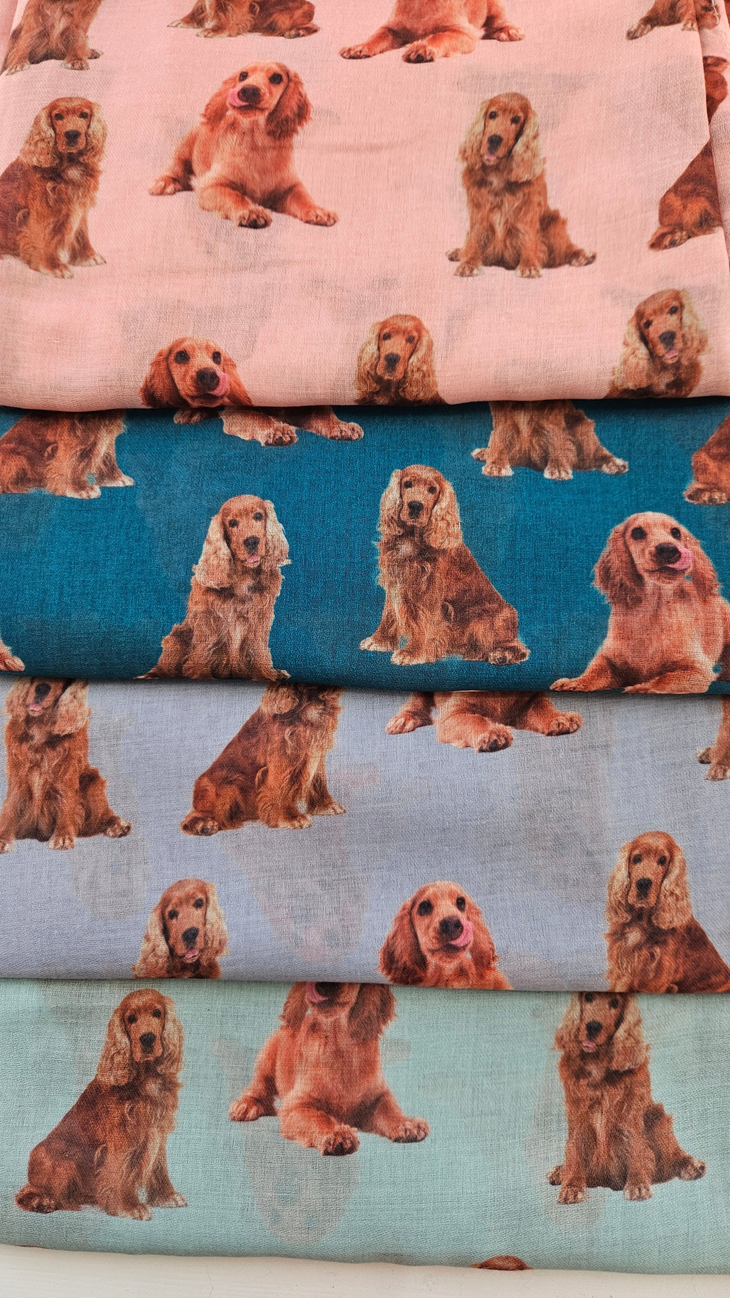Collection of scarves with tan cocker spaniel pattern on a white background