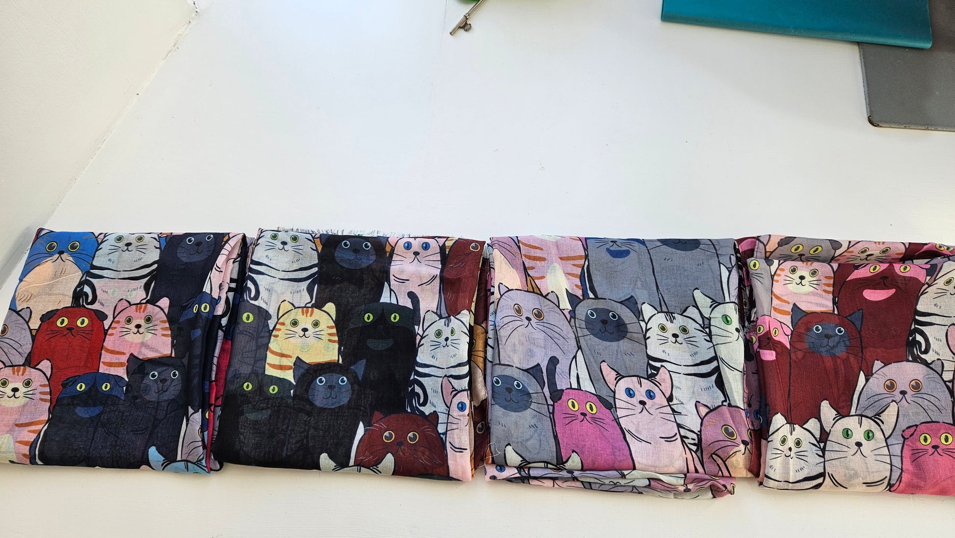 Range of Wide Eyed Cat scarves on white background