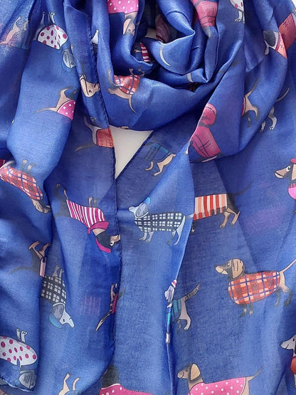 Rolled-up blue scarf with sausage dogs in jackets on a white background