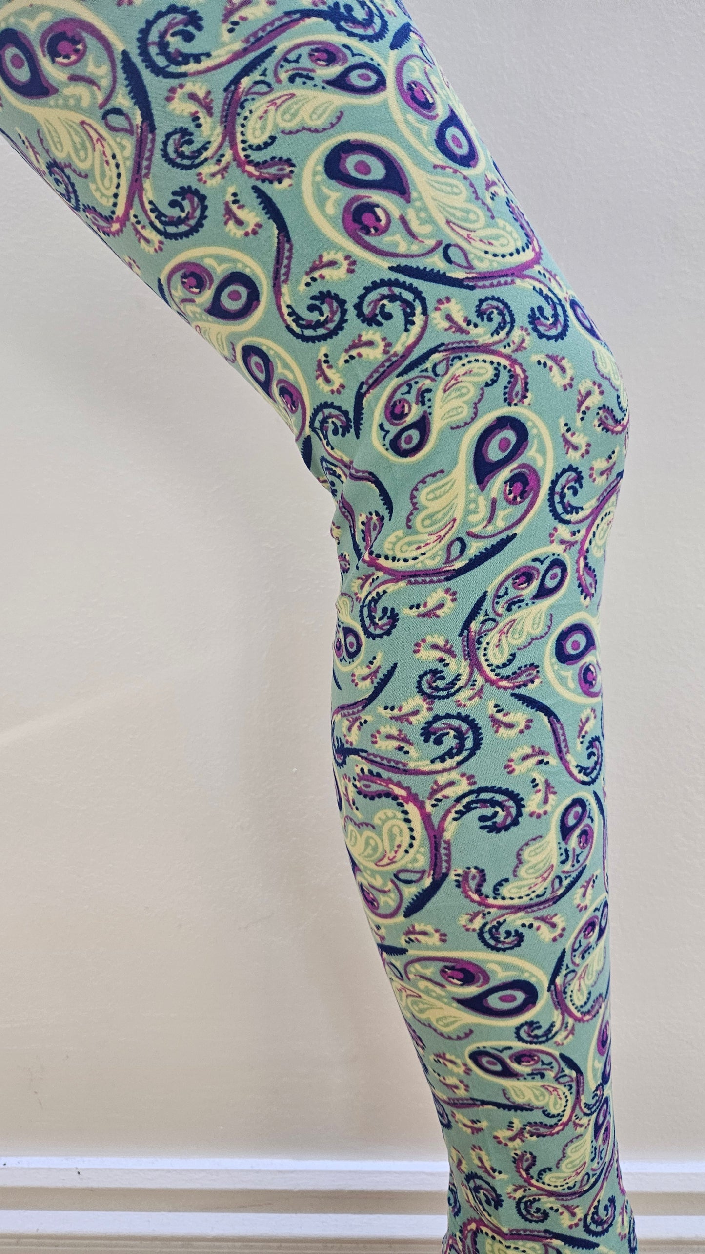 Patterned leggings with paisley design on a light background