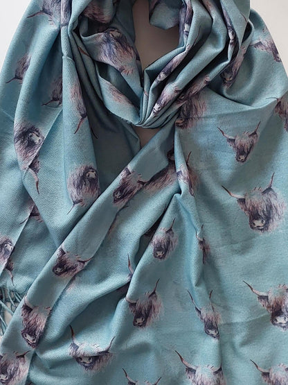 Sage pashmina scarf with black and white highland cow pattern on a white background